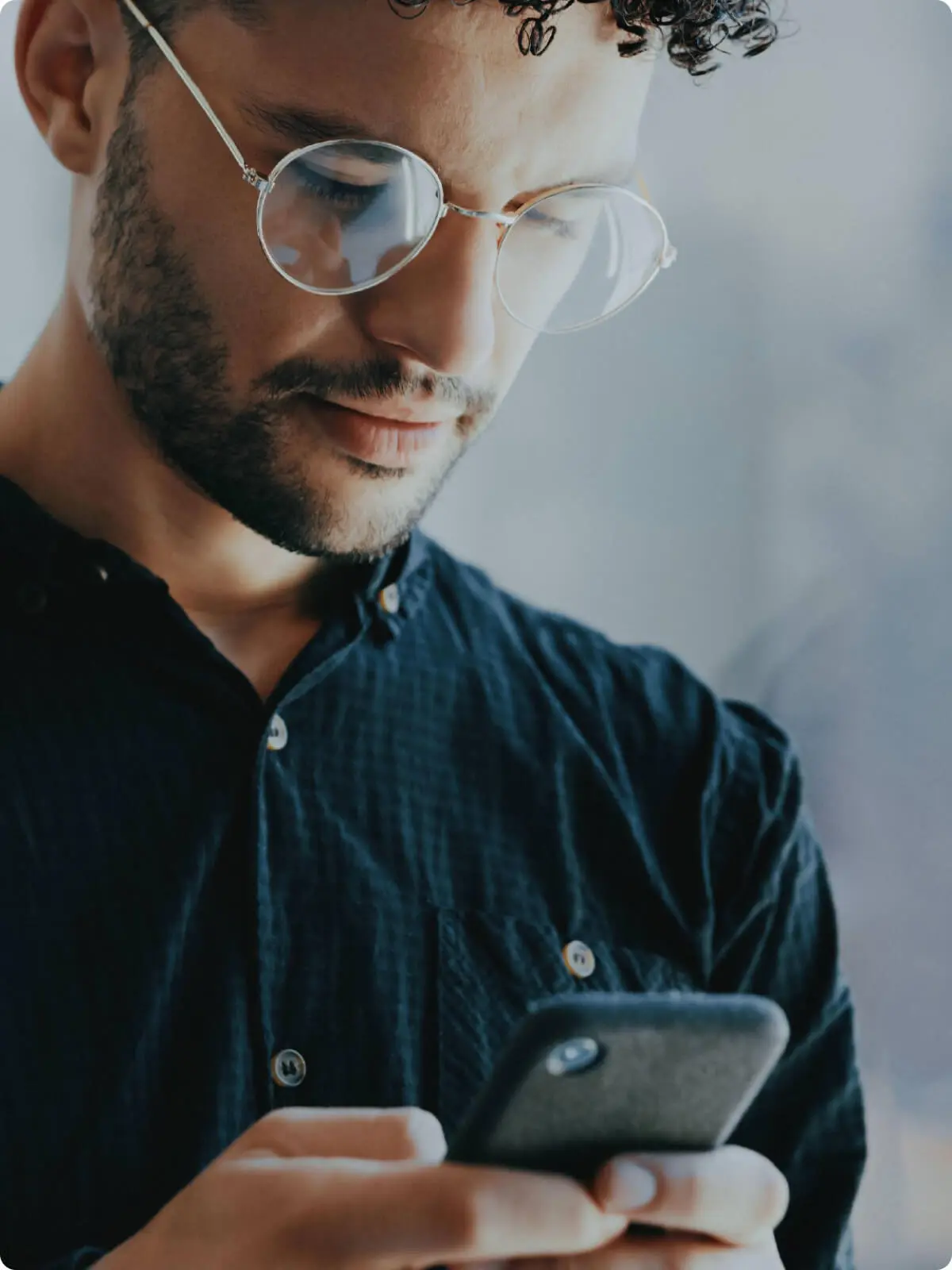 Man with glasses looking at his smartphone