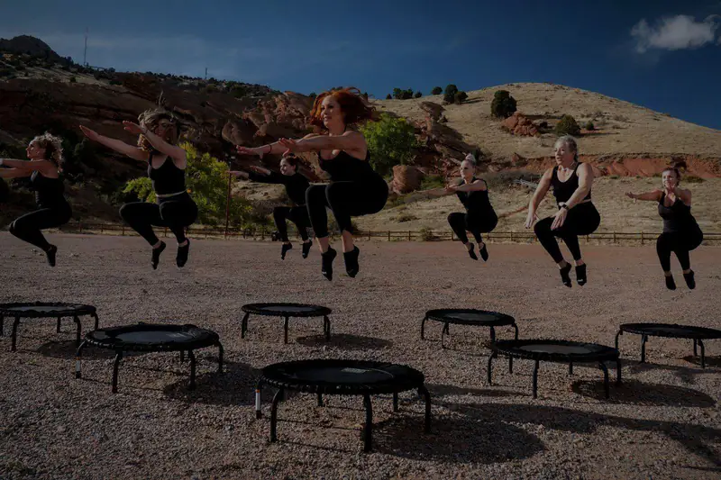 Skupinová lekce jumpingu – ženy ve výskoku nad malými trampolínami