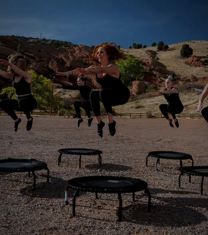 Skupinová lekce jumpingu – ženy ve výskoku nad malými trampolínami