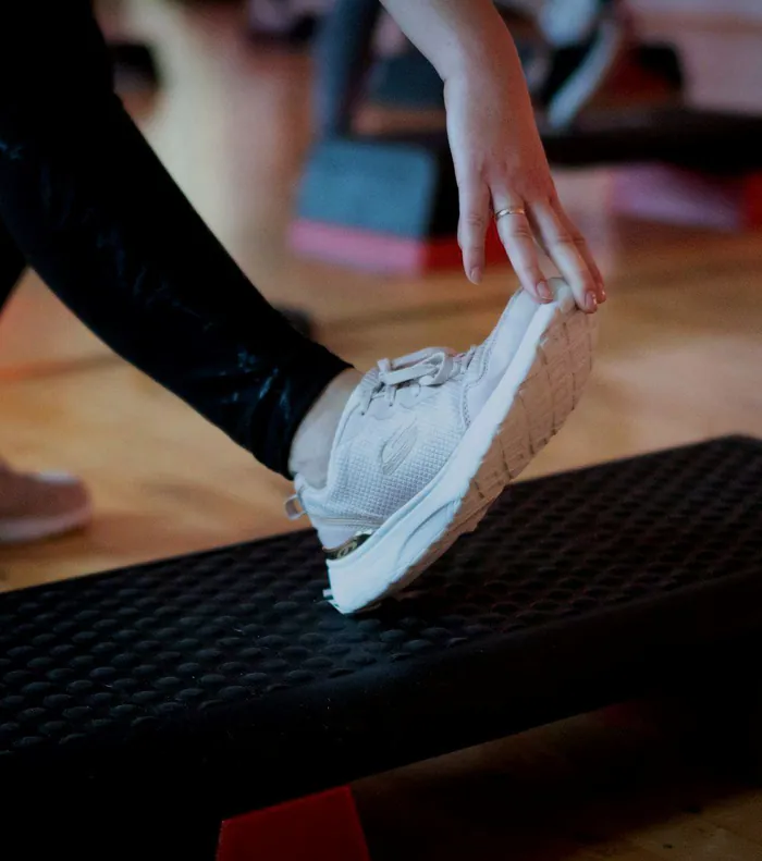 Step aerobik – noha na stepu, v pozadí další stepy lekce