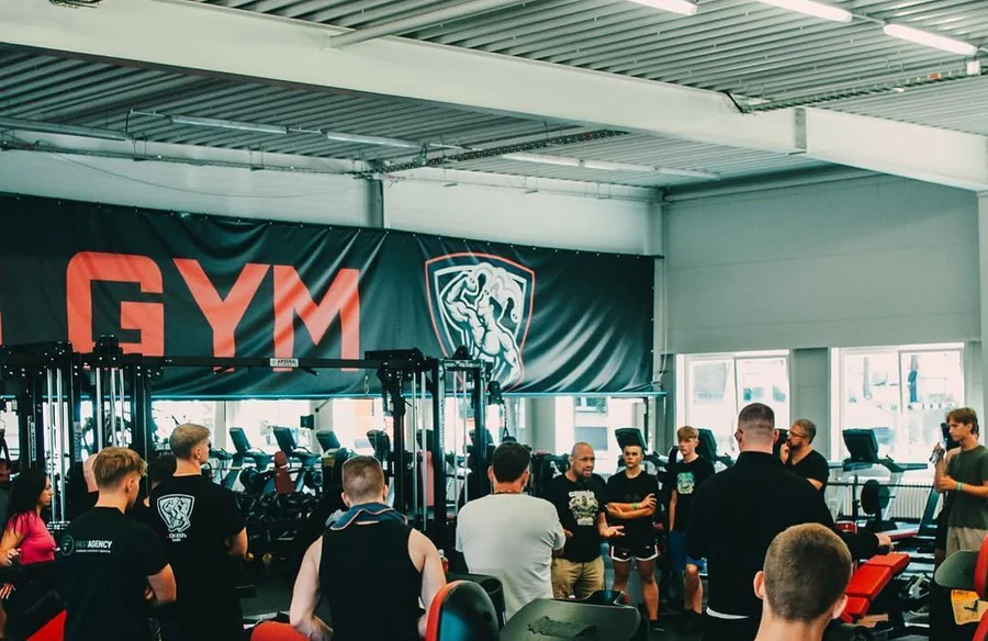 Posilovna Joker's Gym plná členů pod bannerem GYM