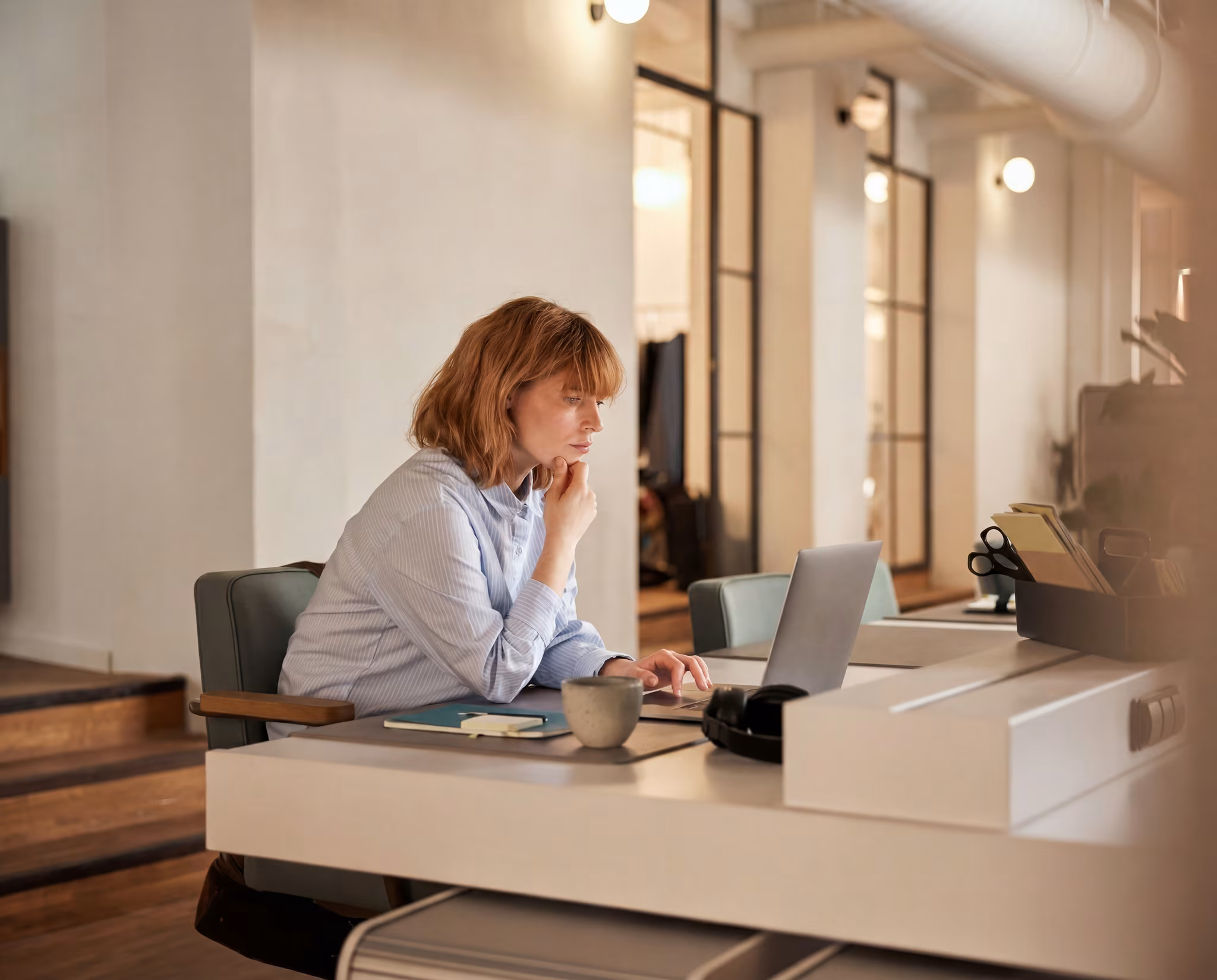 Photo : professionnelle concentrée sur son ordinateur dans un bureau moderne (secteur Digital et Tech)