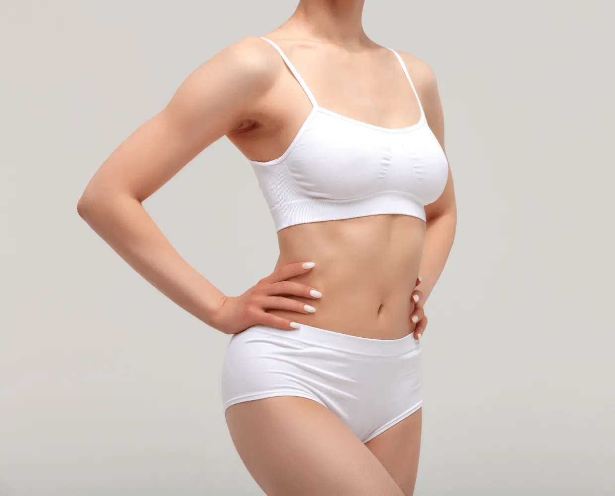Silhouette féminine en sous-vêtements blancs, main sur la hanche