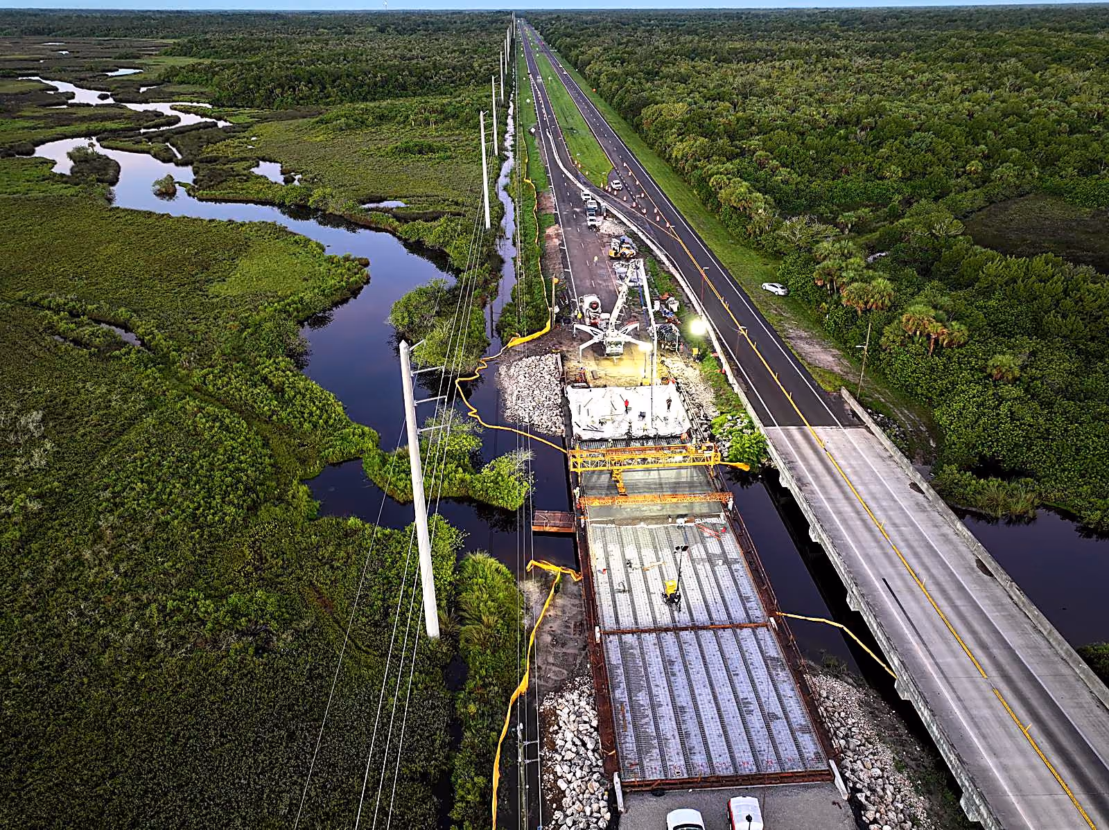 Aerial view of CWR Contracting bridge deck construction over a Florida waterway at dusk