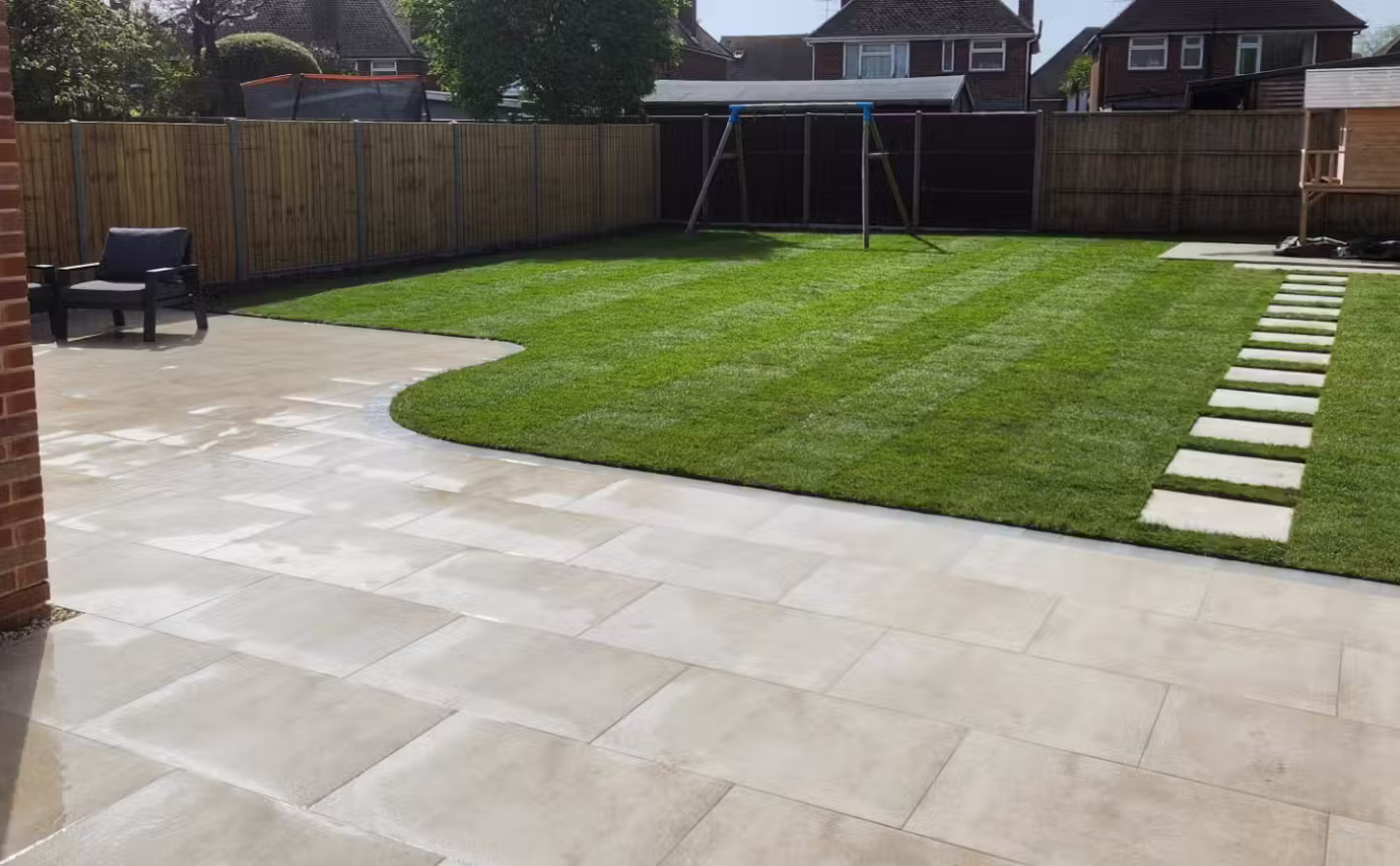 andscaped garden with new patio and green turf lawn after transformation in West Sussex