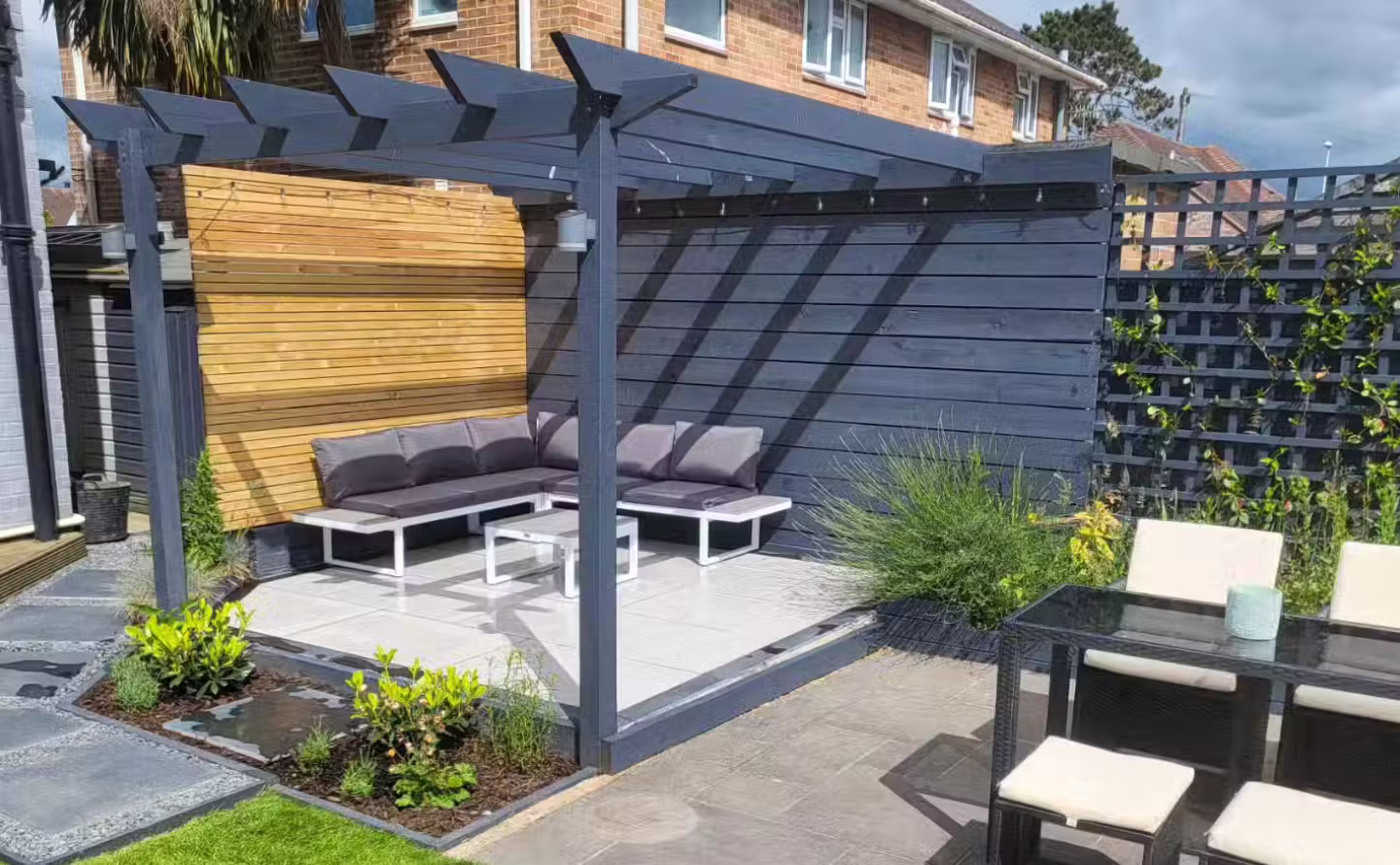 New garden patio with pergola seating area after landscaping in Worthing, West Sussex