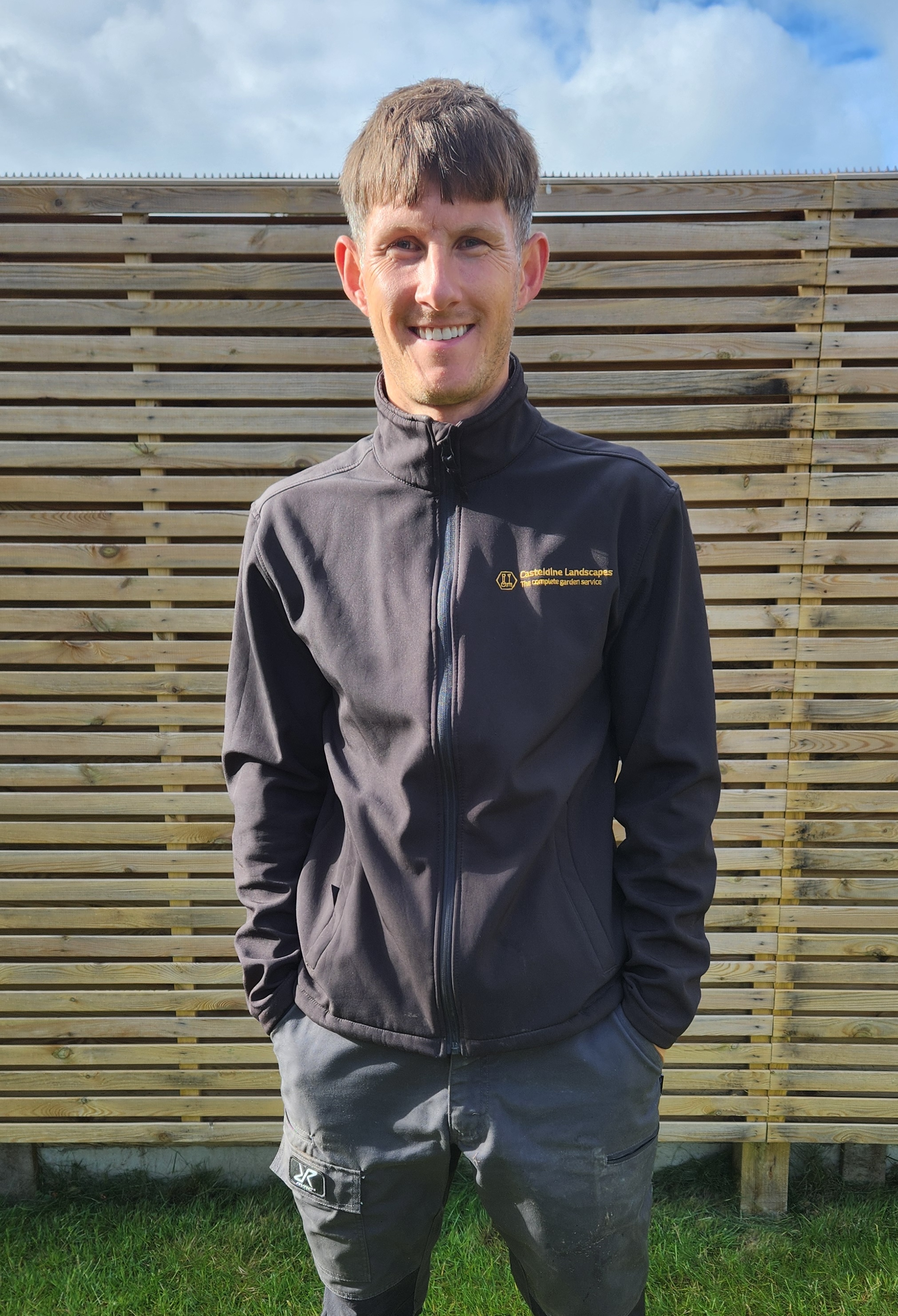 Ryan Casteldine, professional landscaper based in Worthing, West Sussex, seated in a garden
