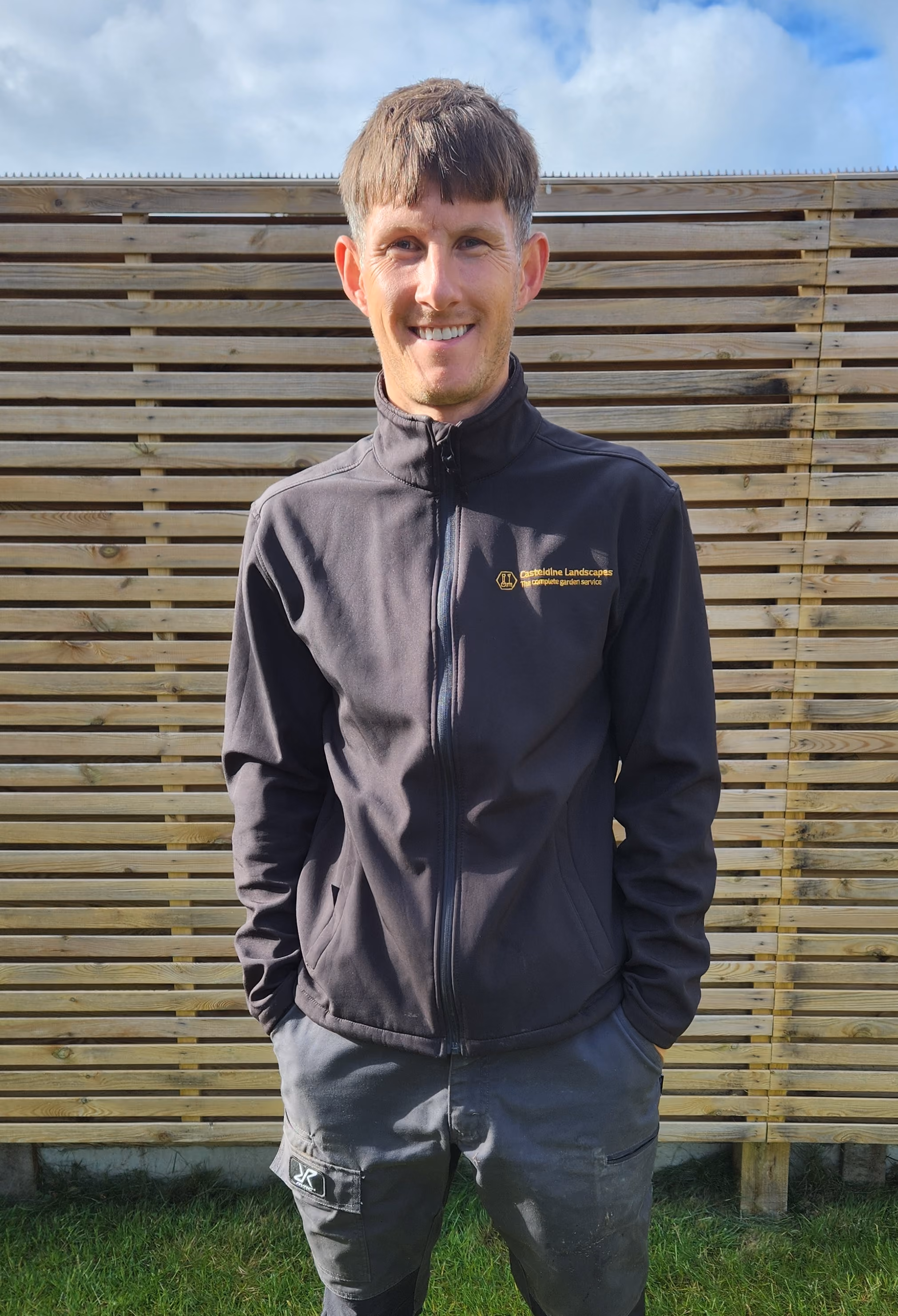 Ryan Casteldine, professional landscaper based in Worthing, West Sussex, seated in a garden