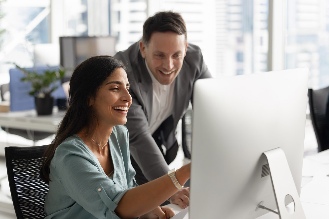 Two creatives working together on an apple desktop computer
