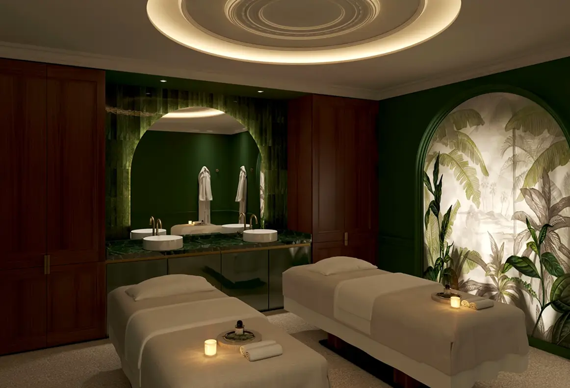 Sala de spa com duas mesas de massagem, iluminação suave, espelho e decoração de parede.