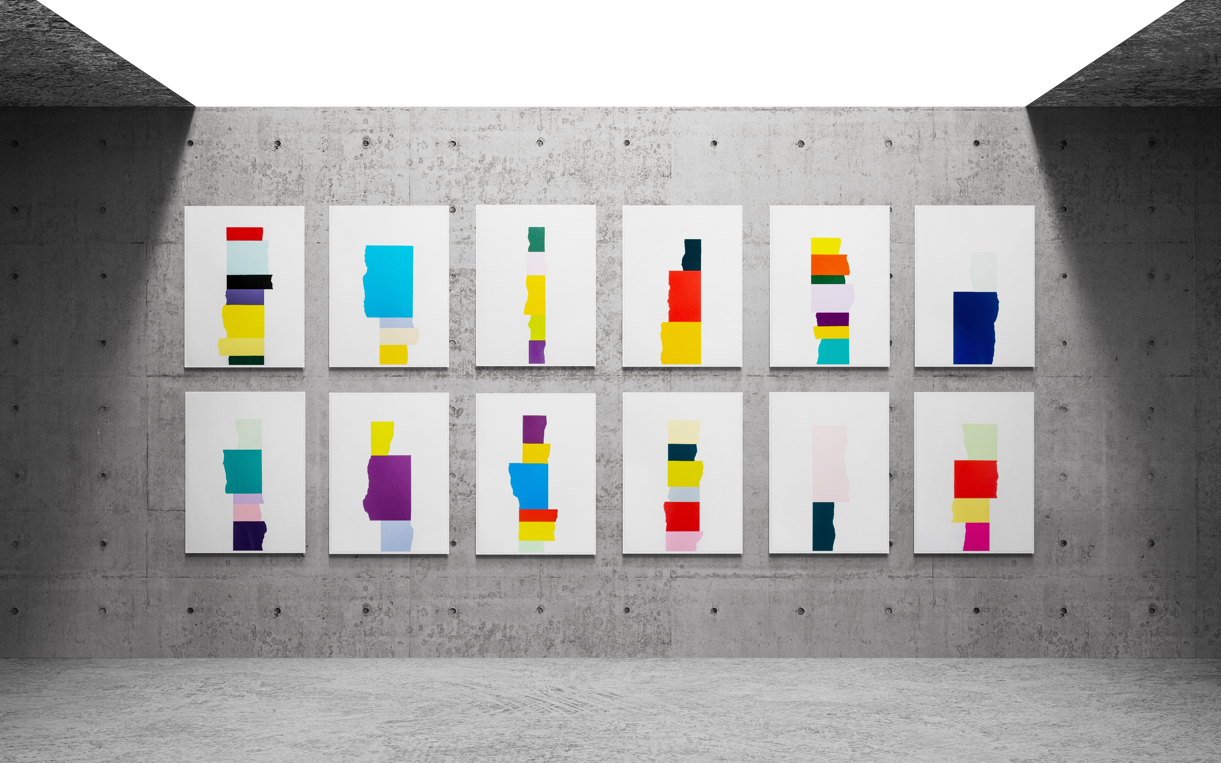 David Batchelor's Chromophilia suite installed on a concrete gallery wall — twelve framed prints in two rows, each a vertical stack of vivid torn-edged colour blocks on white.