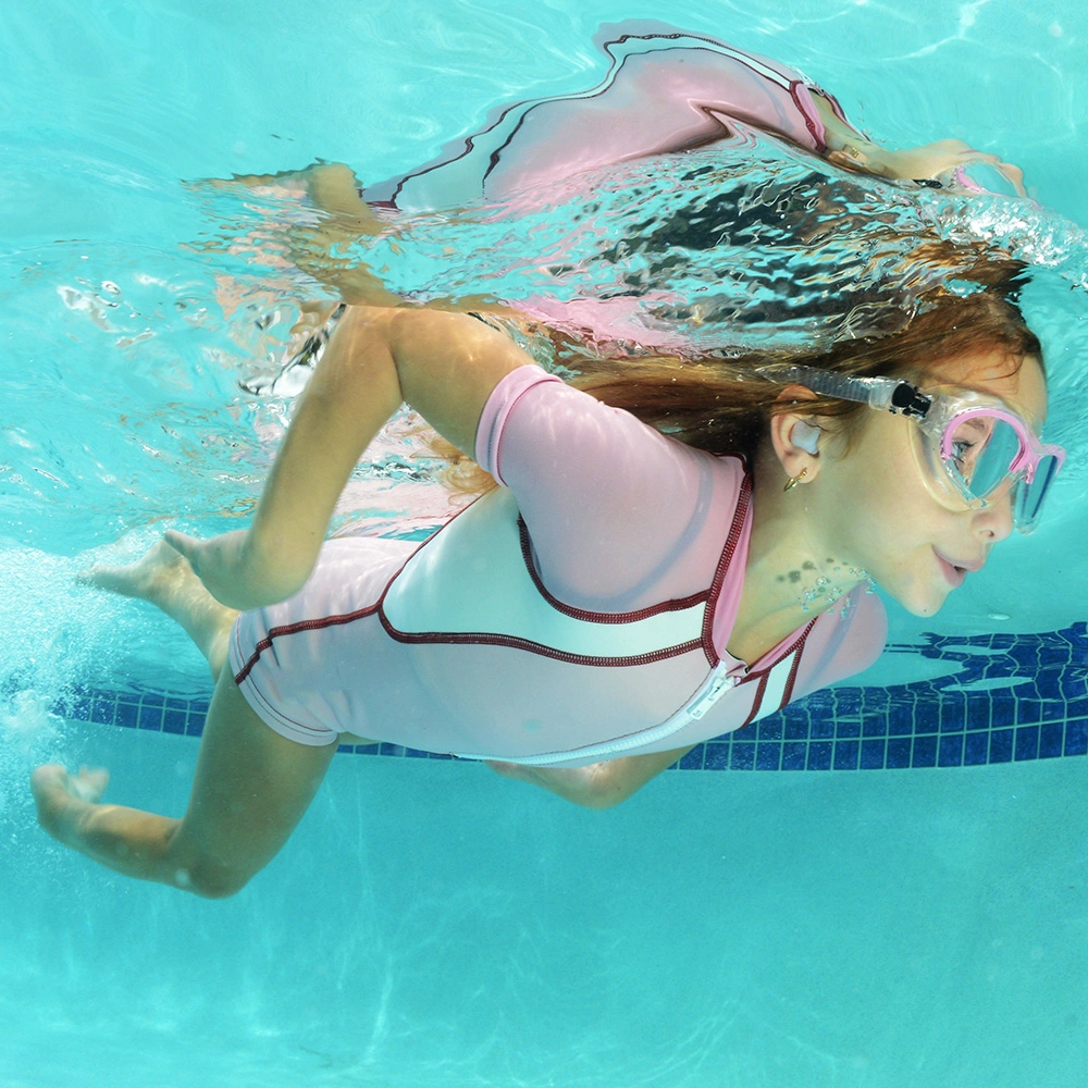 Mädchen schwimmt unter Wasser im Pool Schwimmbrille.