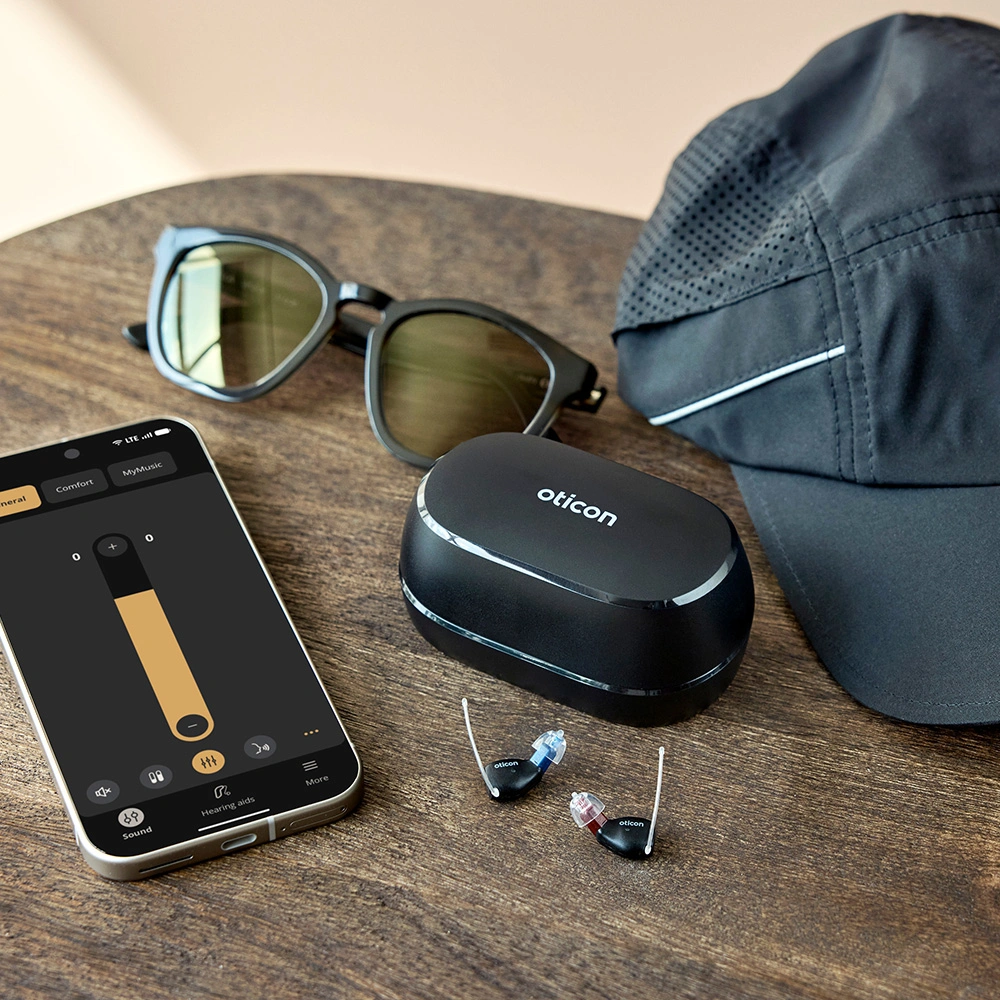 Oticon Zeal Größenvergleich mit App auf dem Handy