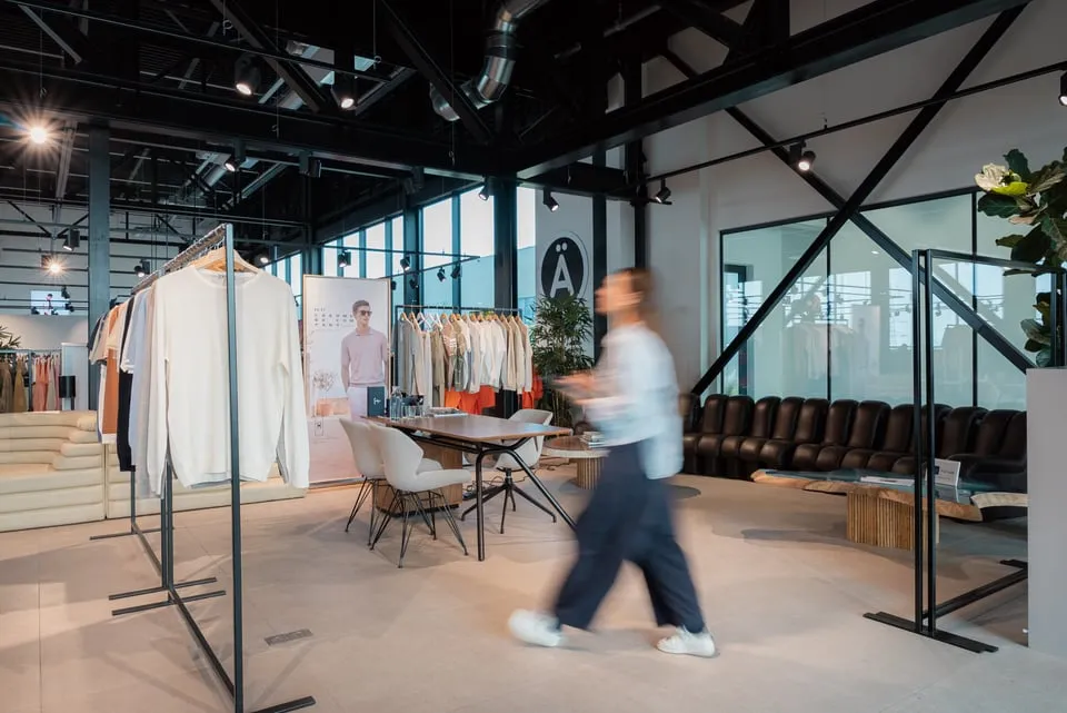D-LUX team working behind the scenes near a clothing rack