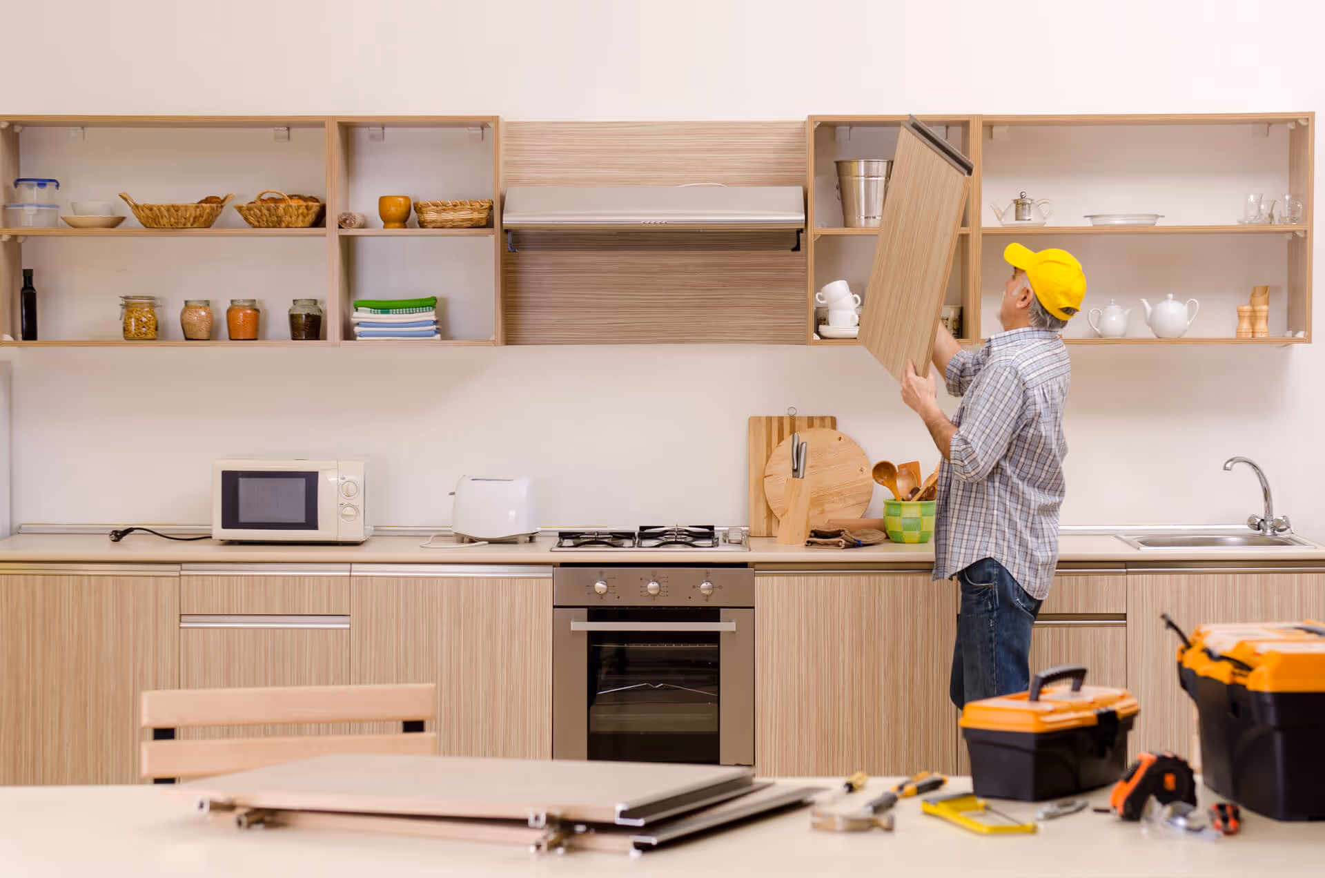 remodeling carpenter working on hanging cabinets in a kitchen