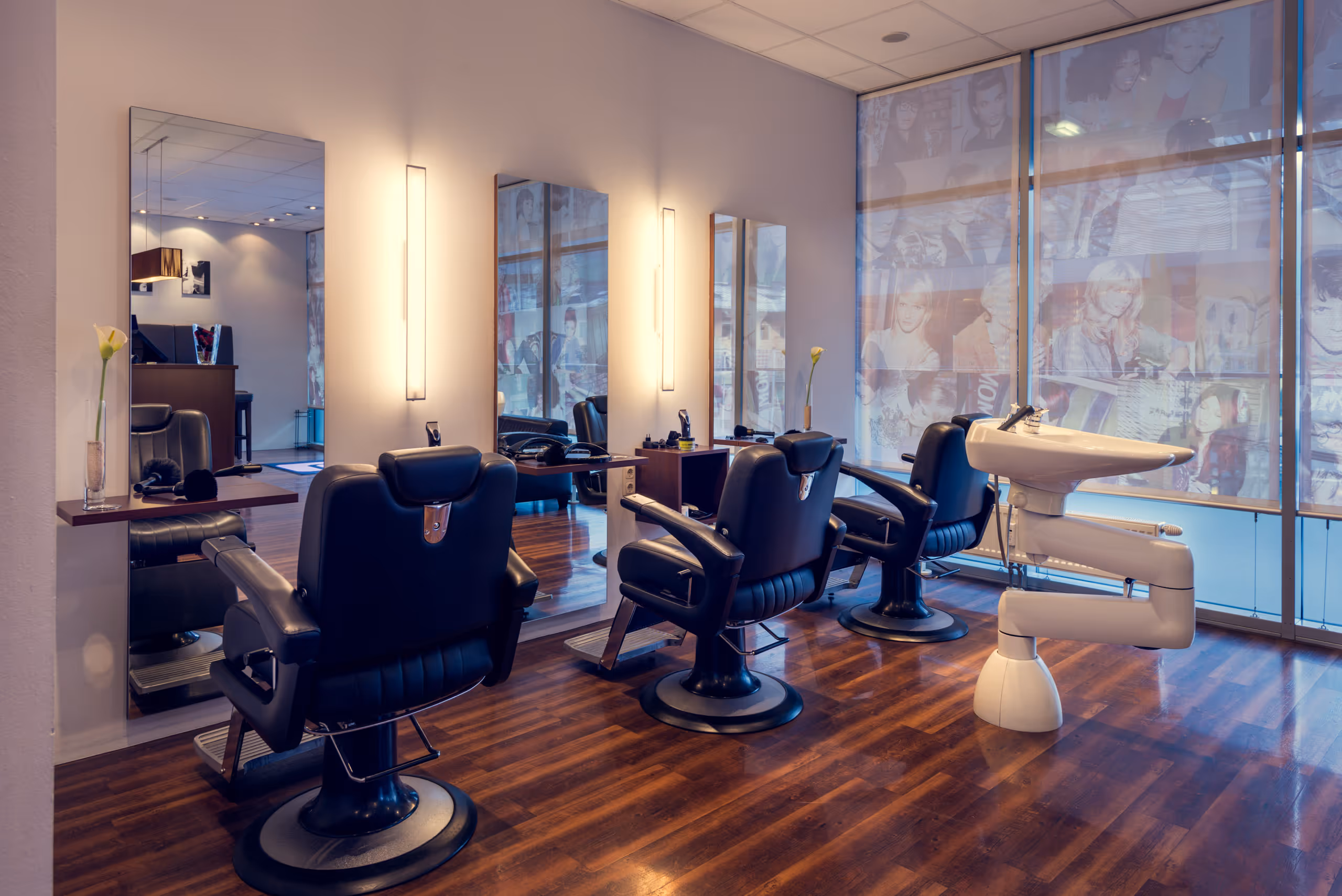 Ansicht des Herrenbereichs im Friseursalon mit drei großen Stühlen und einem speziellen Waschbecken für Friseure