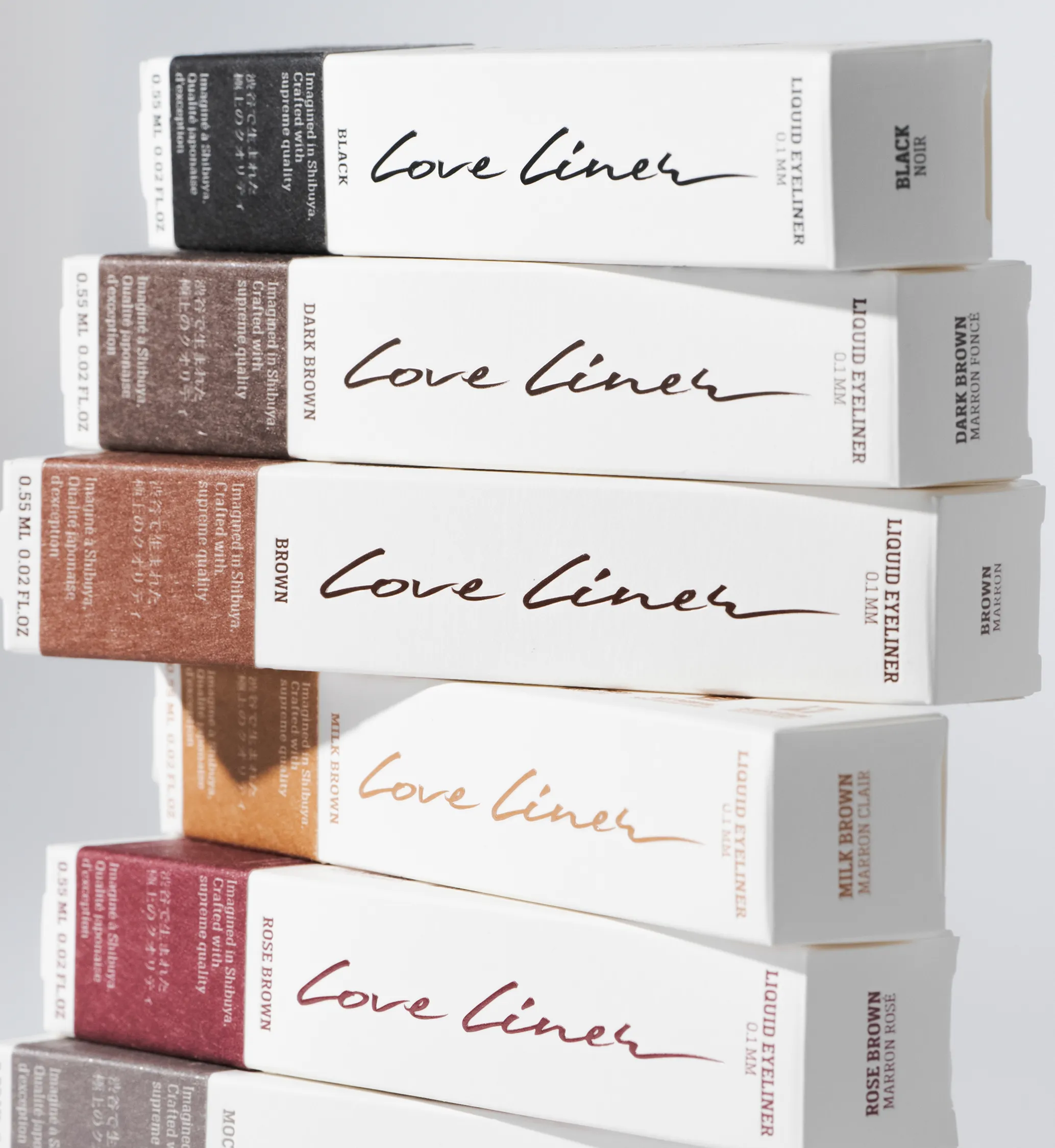 Stack of Love Liner liquid eyeliner boxes in black, dark brown, brown, milk brown, and rose brown colors.