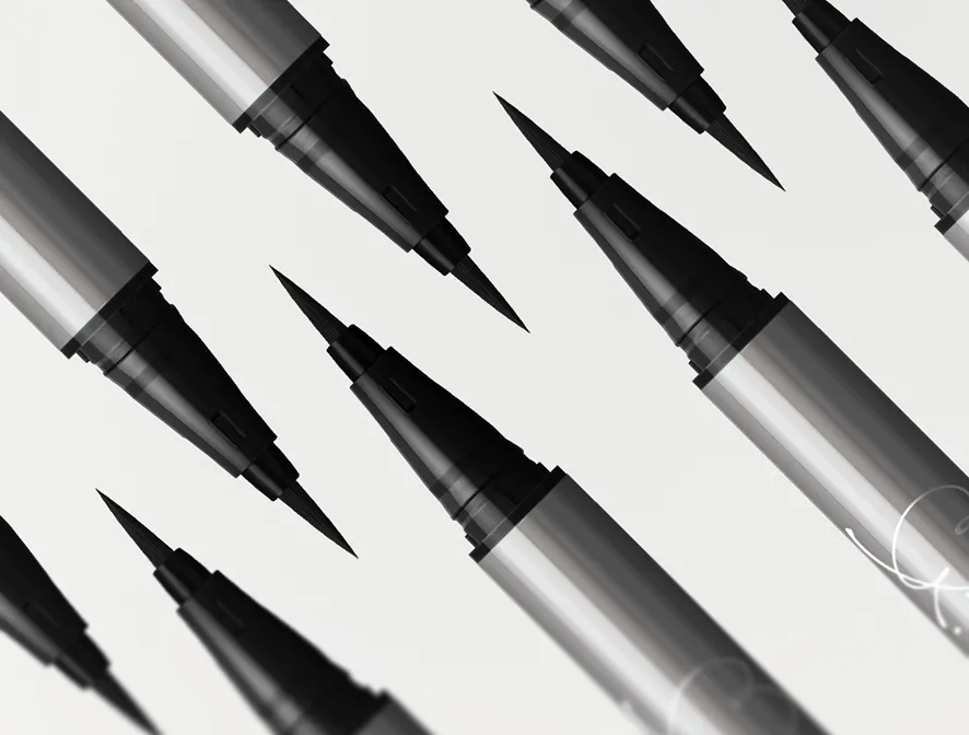 Close-up of multiple black felt-tip eyeliner Liquid love liner pens with silver barrels on a white background.