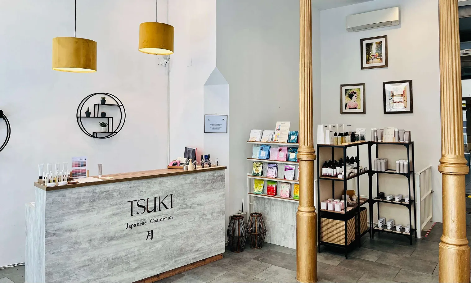 Minimalist Tsuki Japanese Cosmetics store with a reception counter, product shelves, and yellow pendant lights.