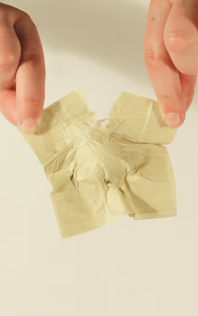 Hands tearing tea packaging in half