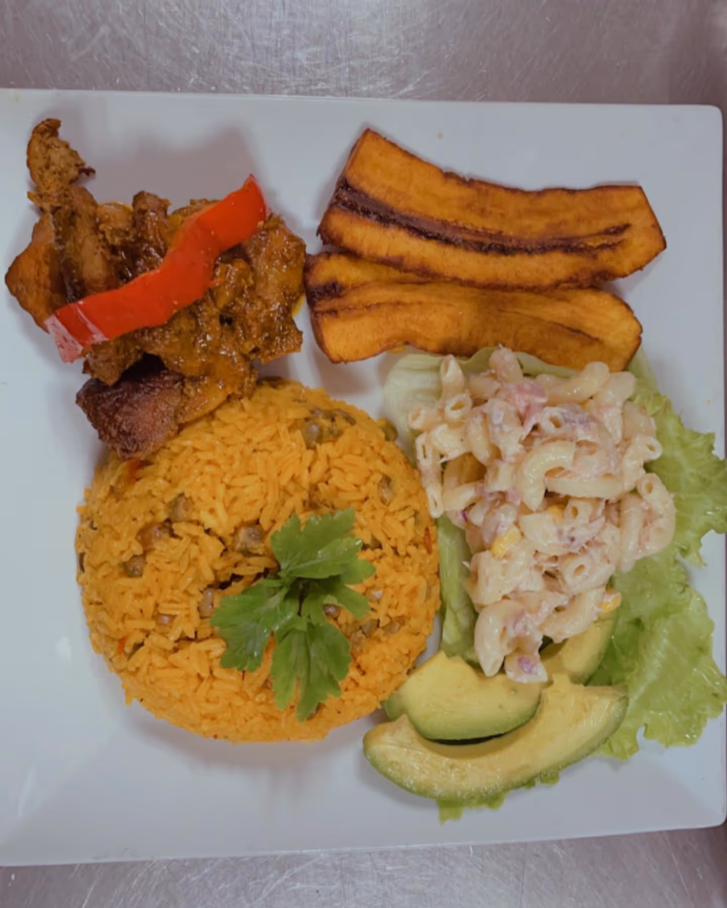 A plate of food with rice, meat, and vegetables.