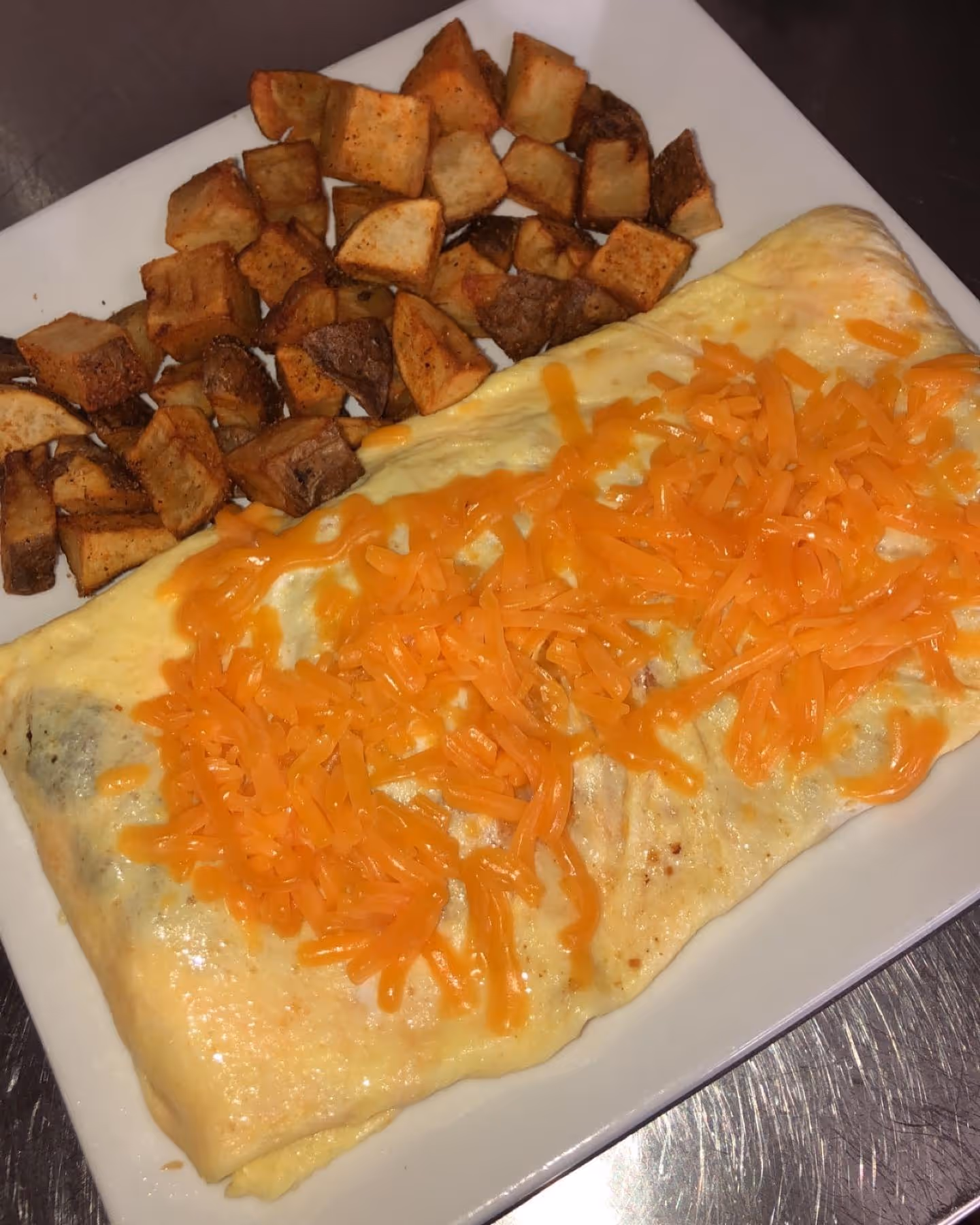 A plate of food with cheese and potatoes.