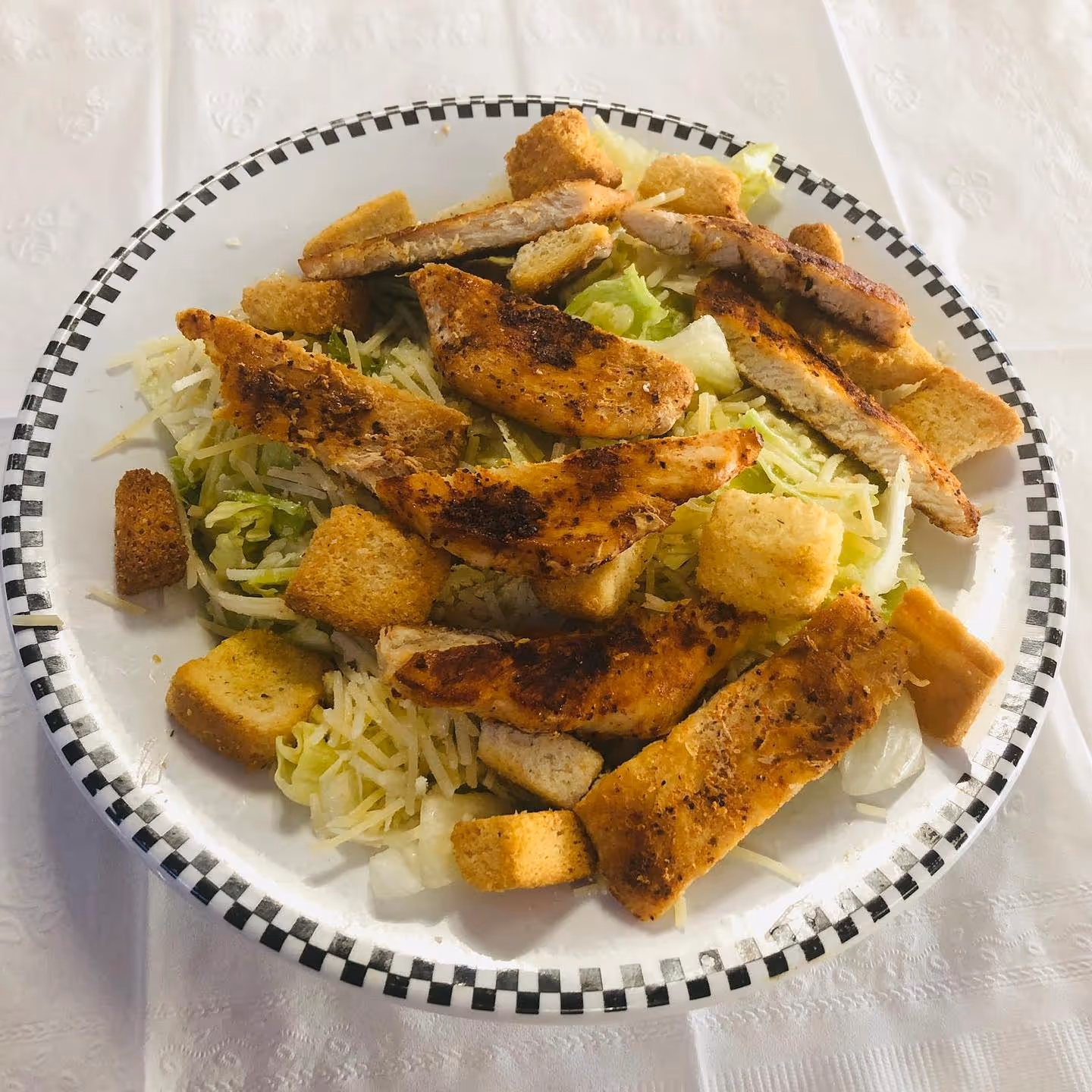 A plate of food with chicken, bread, and lettuce.