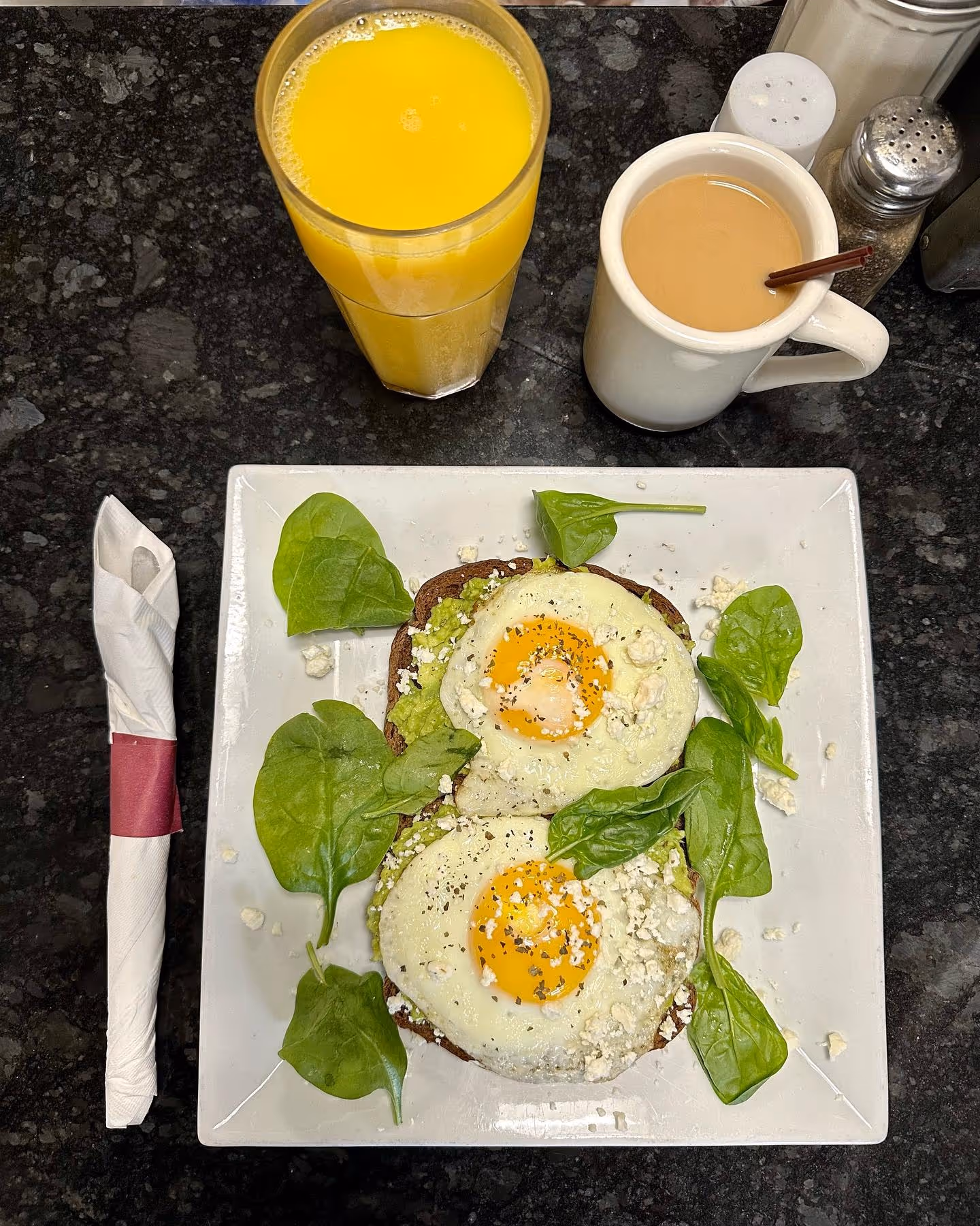 A plate of food with eggs and greens on a table.