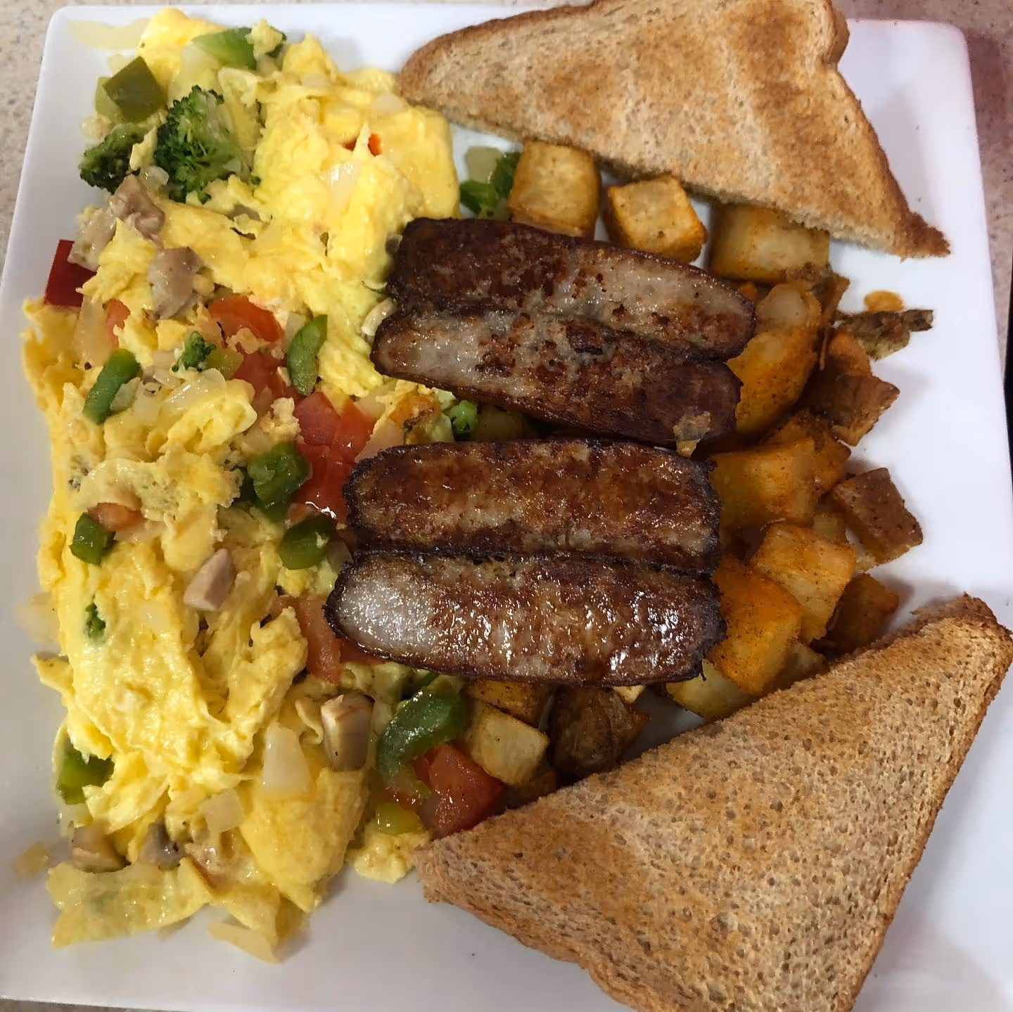 A plate of food with eggs, toast, and potatoes.
