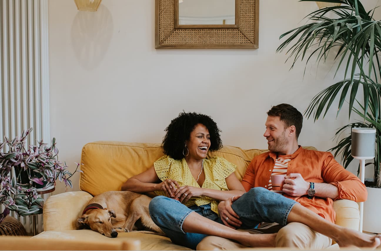 Couple relaxing at home with their dog
