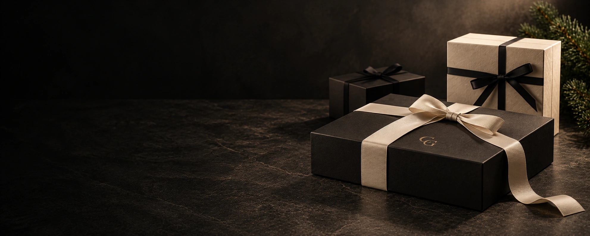 Black Capital Gifts gift box tied with a cream ribbon, beside a cream and a black gift box