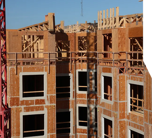 A multi-story building is under construction, with wooden framing and scaffolding visible.