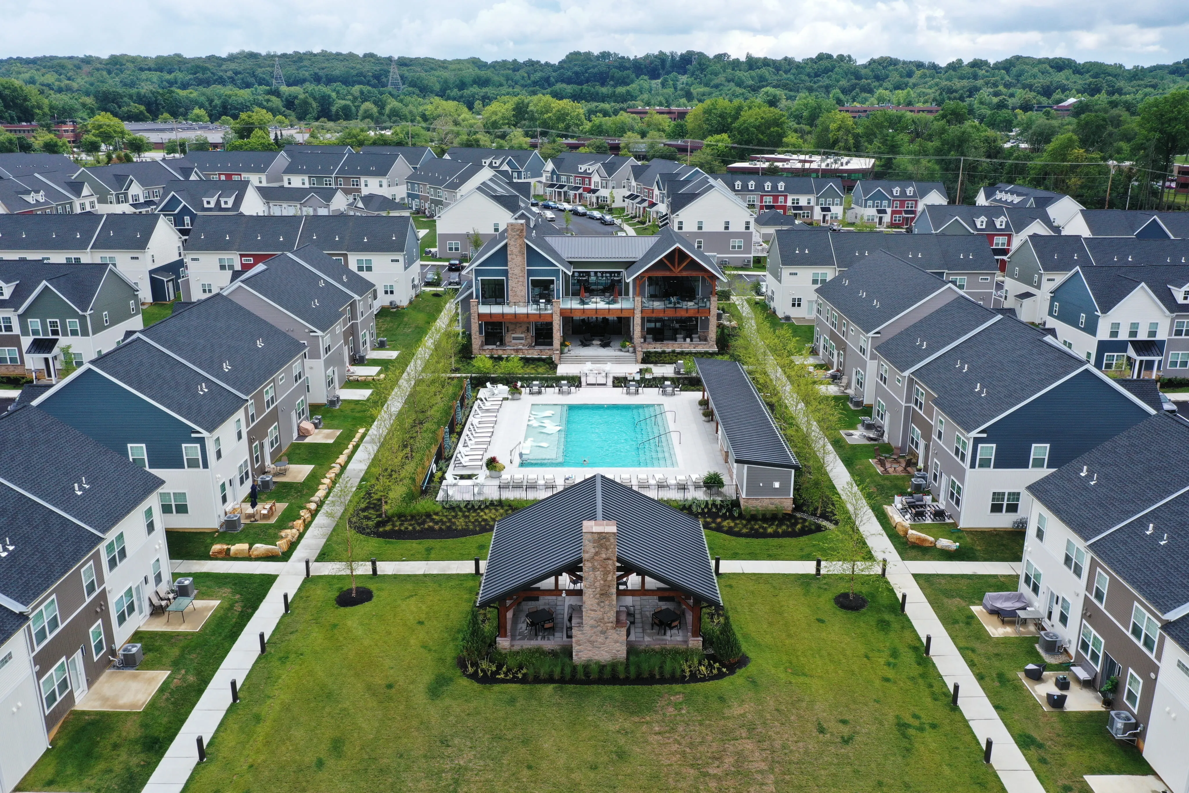 Aerial view of a residential neighborhood with a large central swimming pool and clubhouse.