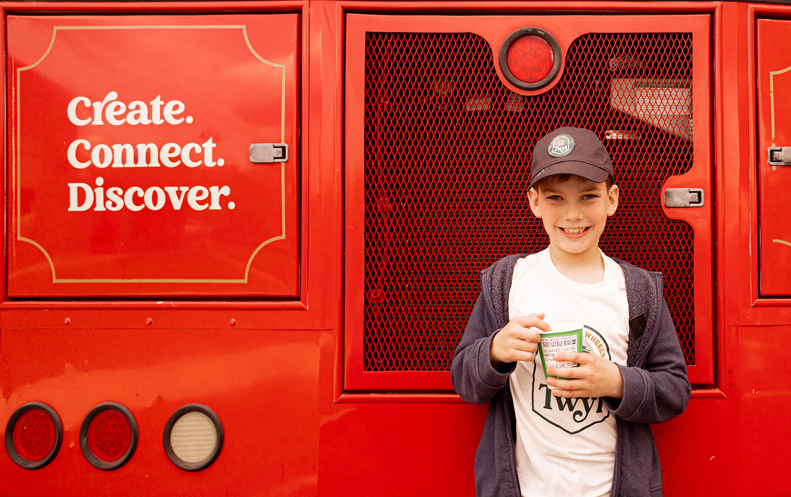 A boy stands in front of the trolley