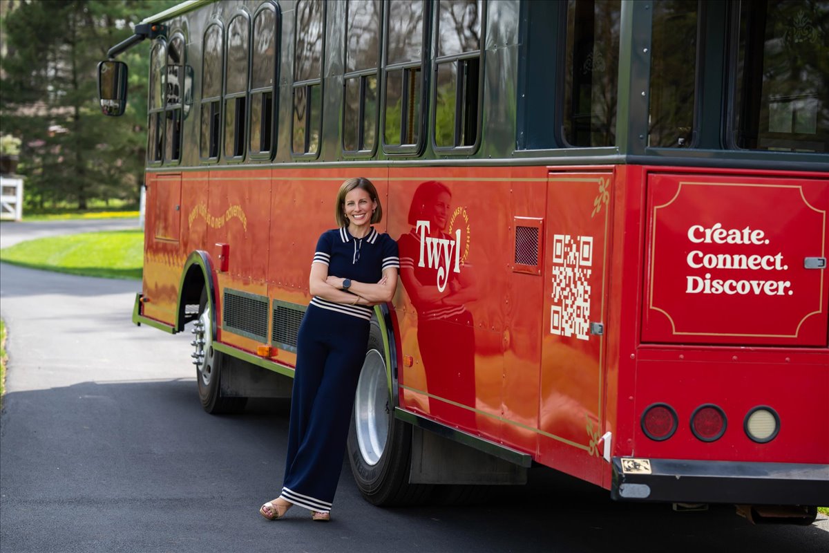 A woman stands against the side of the trolley