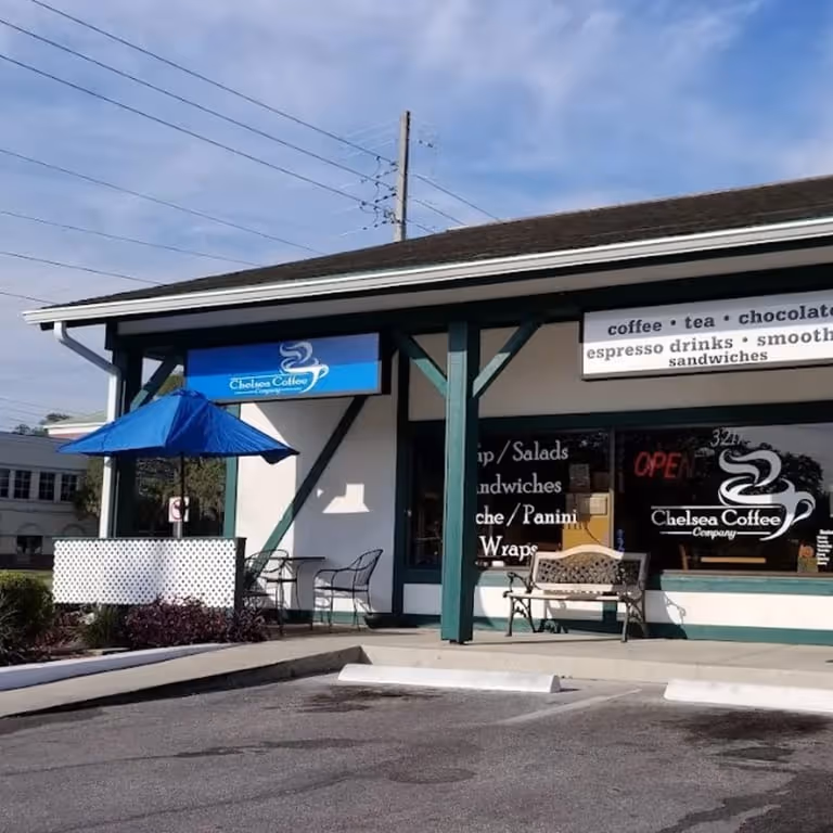 Chelsea Coffee Company storefront with outdoor seating, blue umbrella, and parking spaces in front.