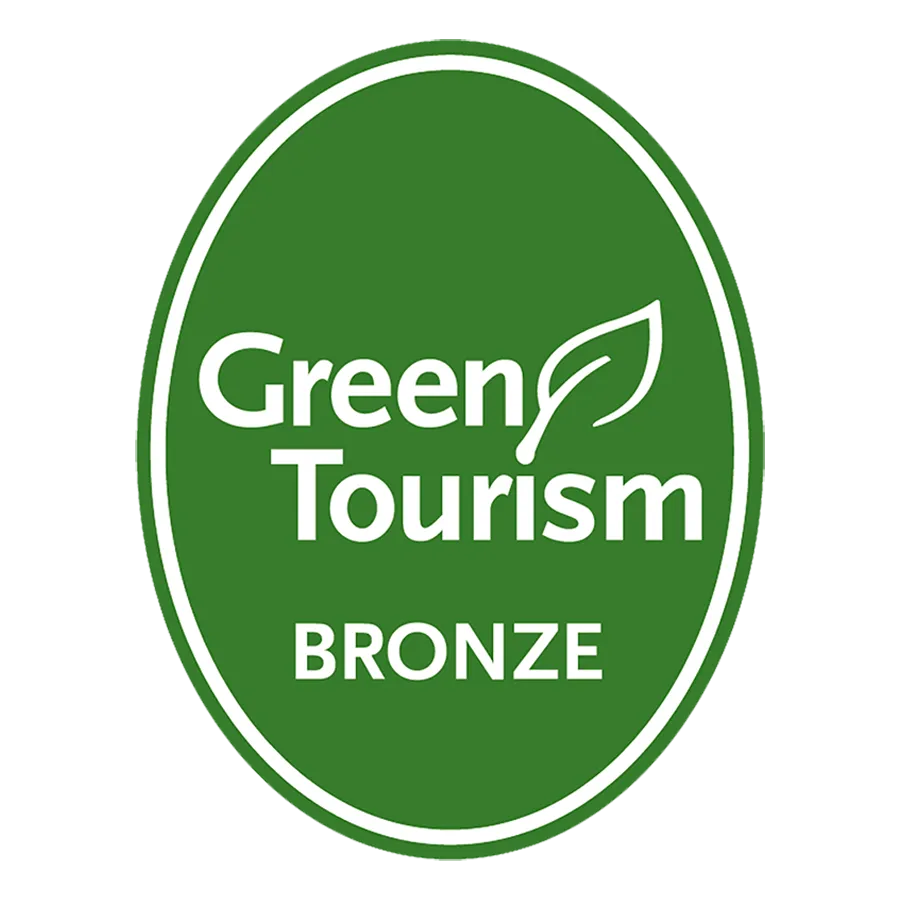 Green Tourism Bronze badge with a white leaf icon on a green oval background.