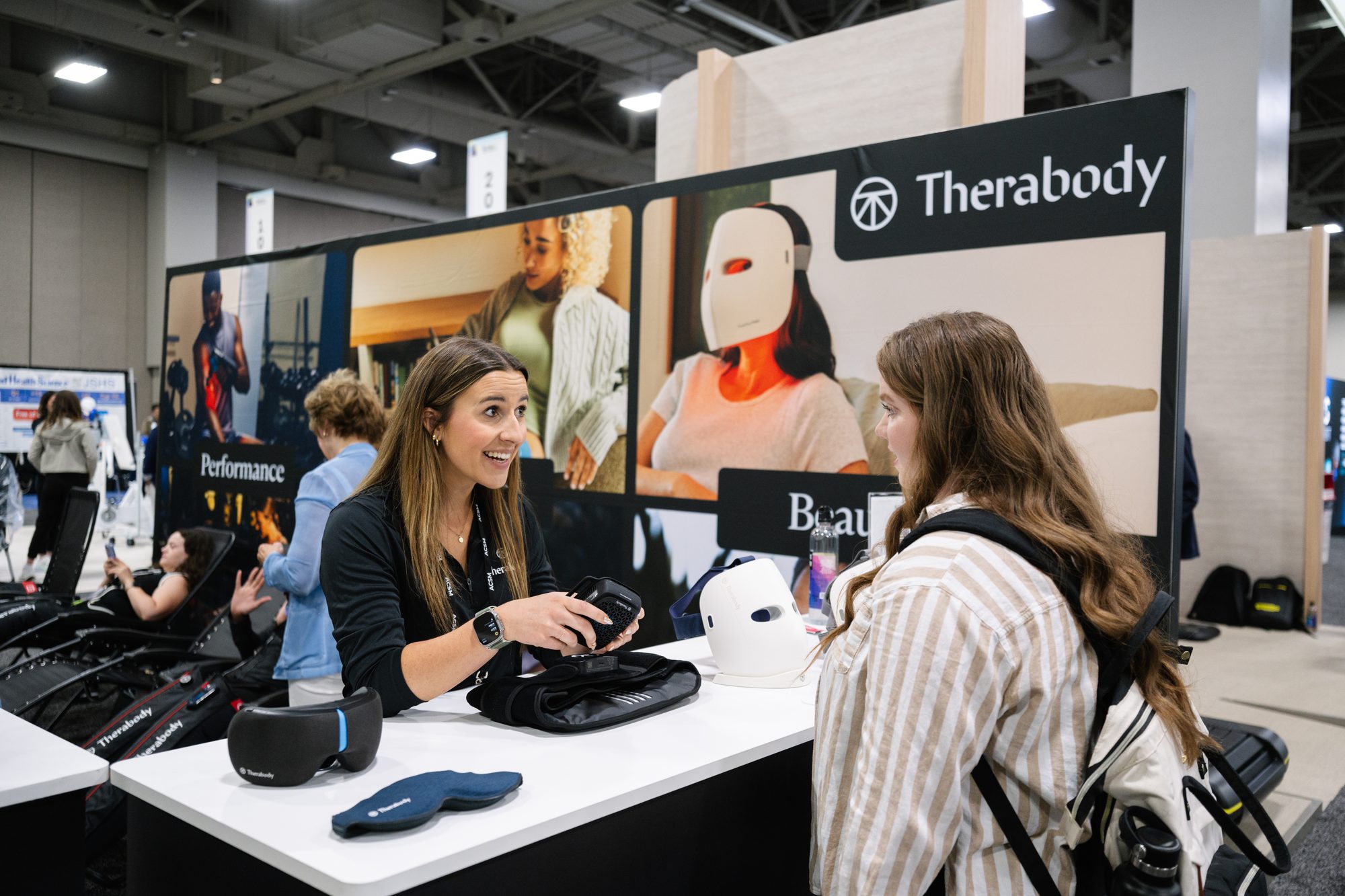 Sponsor representative talking with an attendee at a branded exhibit booth