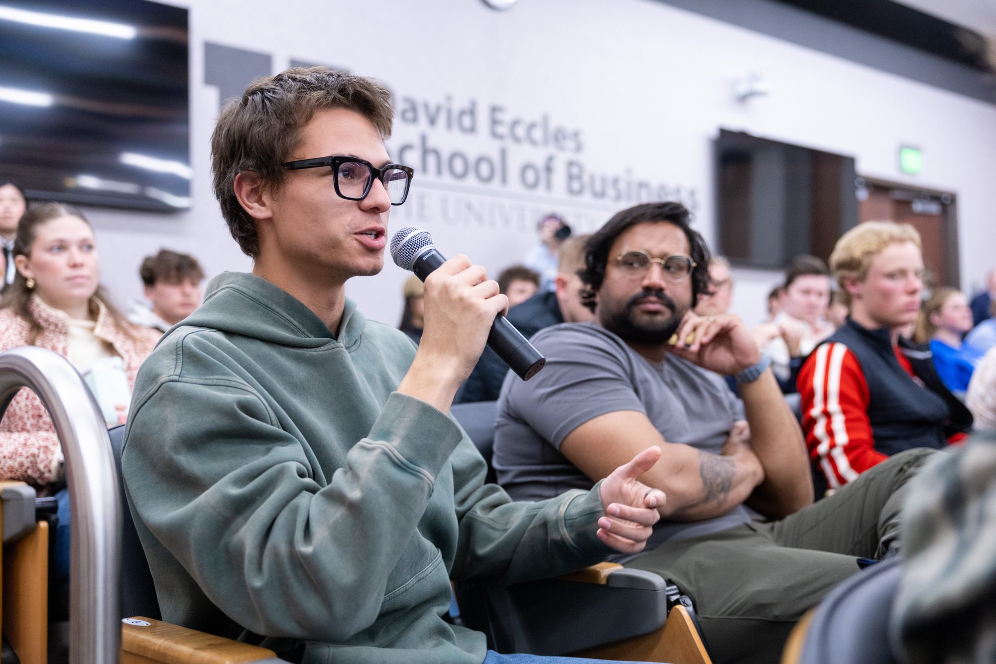 Attendee asking a question on a handheld microphone during audience Q and A