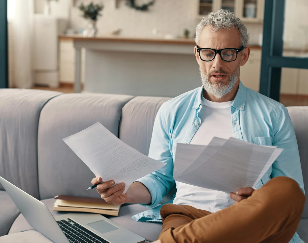 man holding and looking at documents
