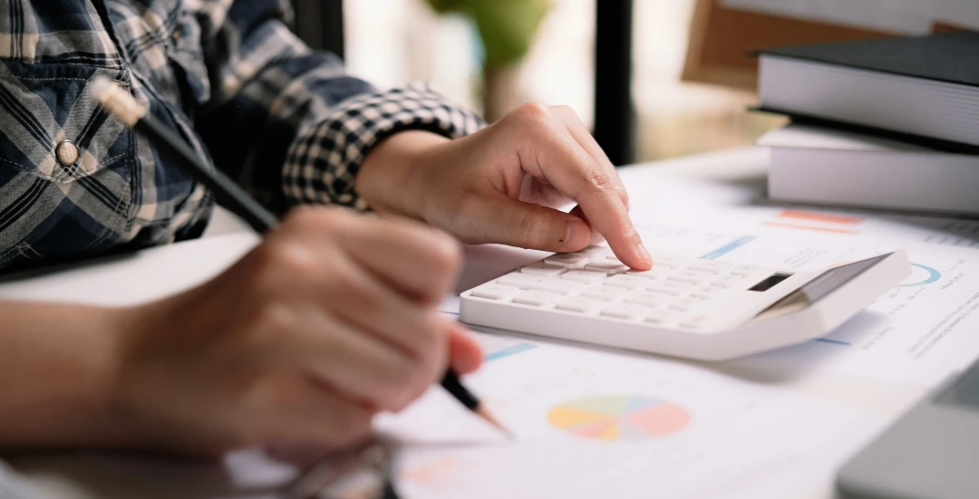 using calculator while making notes on document with diagram