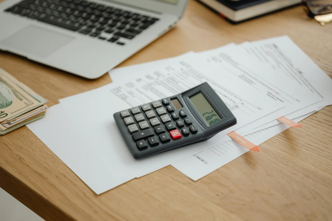 calculator sitting on desk with documents and money