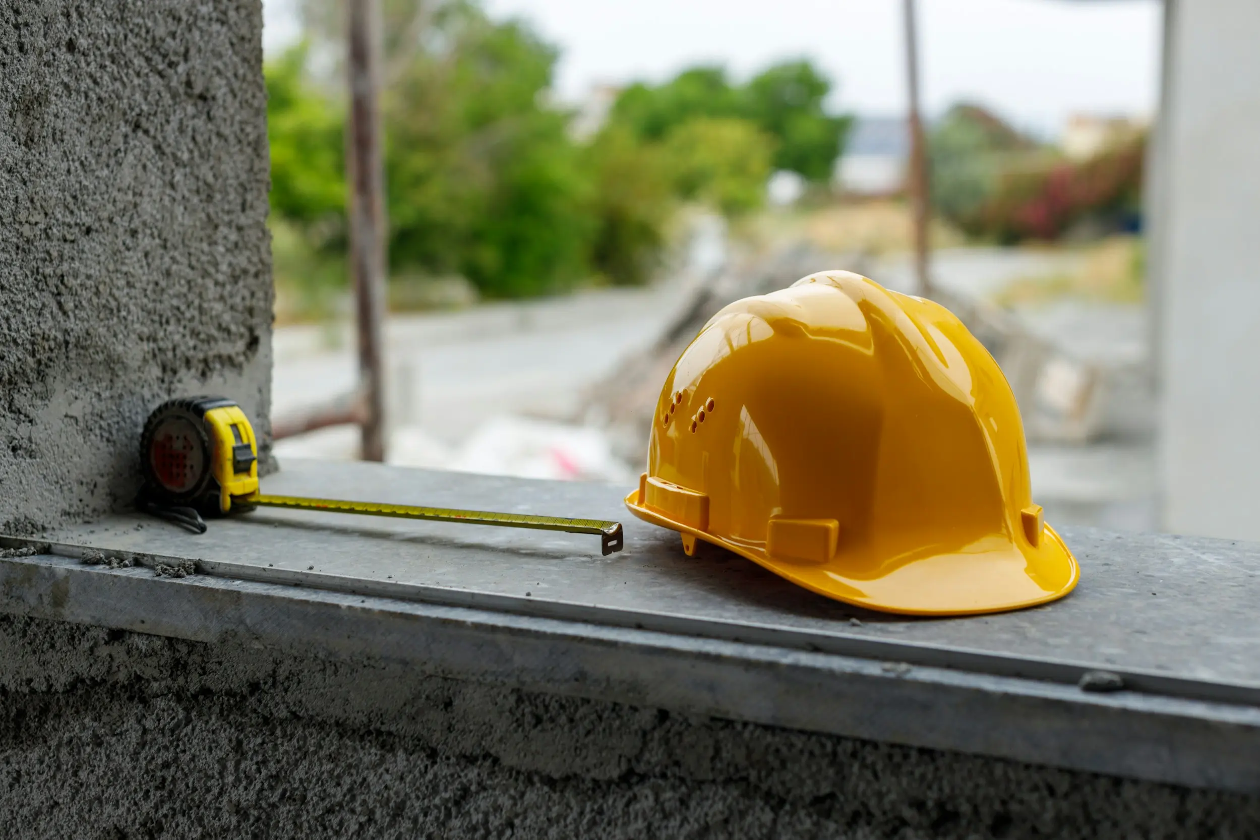 yellow hard hat and tape measure sitting on ledge