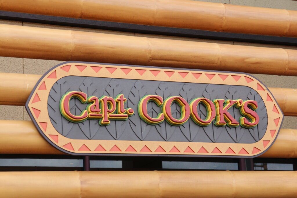 A Polynesian style Capt. Cook's sign for the Disney quick service restaurant featuring bamboo, earth tones and leaf embossing.