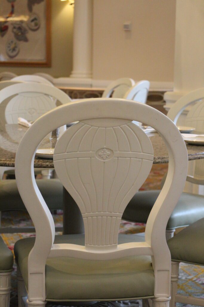 A white chair with a hot air balloon on the back at Grand Floridian Cafe