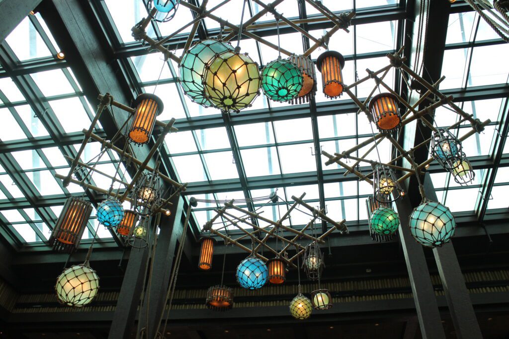 Netted, colorful buoy lights hang in the Polynesian resort lobby below a glass ceiling