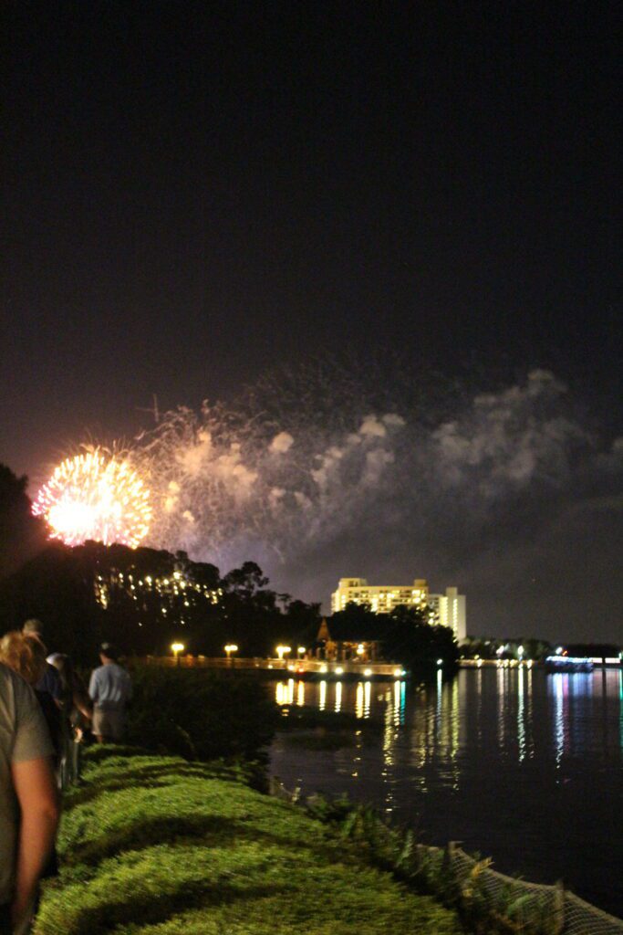 The Wilderness Lodge fireworks view from behind Geyser Point Bar and Grill. Some trees obstruct the view.