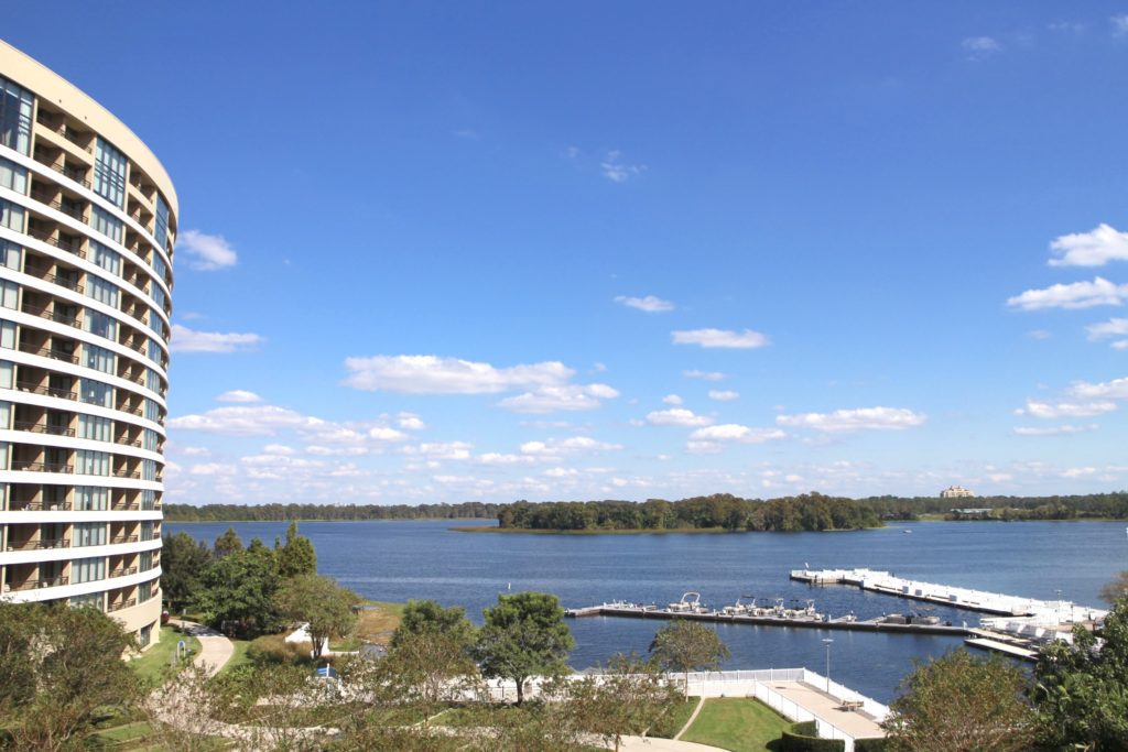 Bay Lake Tower building overlooks the waters of Bay Lake in front of a blue sky with clouds