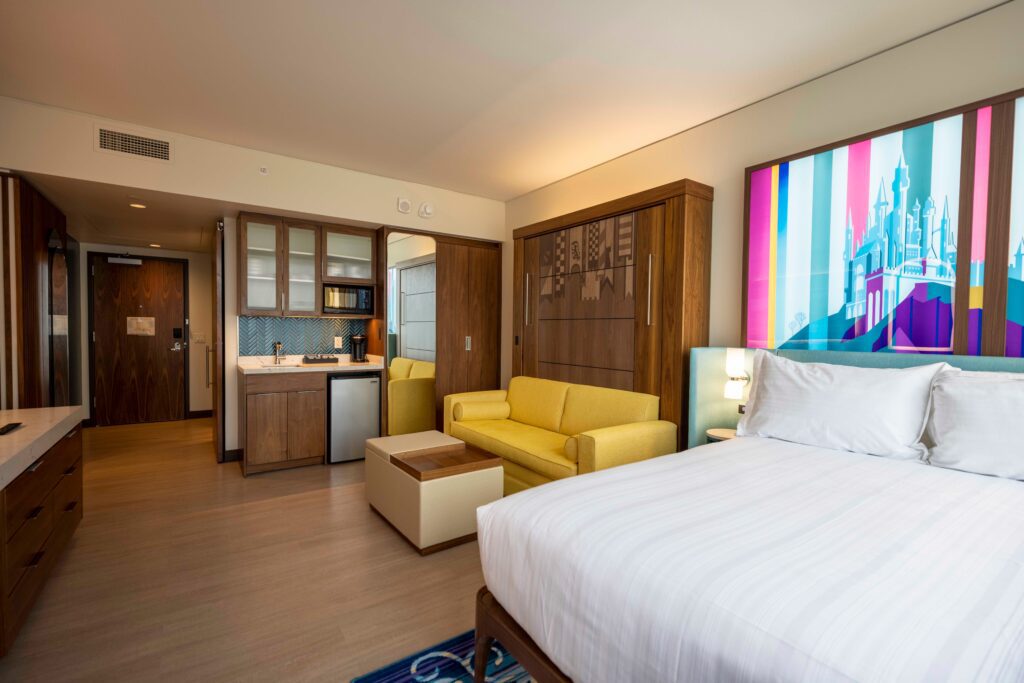 Sleeping beauty themed deluxe studio with a bed and a couch and a kitchenette and lots of wood furniture