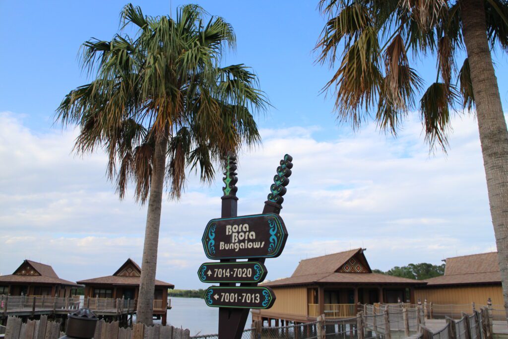 Bora Bora Bungalows directional sign at Disney's Polynesian resort with bungalows in the background under a cloudy blue sky